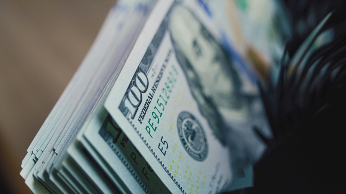 Cash counting machine counts hundred dollar bills.